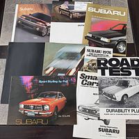 Group shot of all nine Subaru brochures partially overlapped