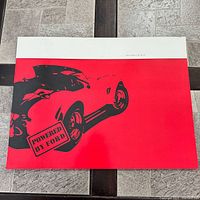 Front cover with red background, black illustration of sports car, Powered By Ford label