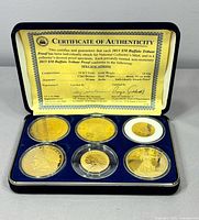 Coins in presentation case with COA visible inside lid