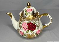 Left side view of teapot showing roses and gold trim