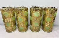 Front view of four green Prado highball glasses