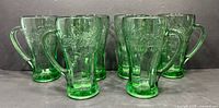 Front view of all six green Coca-Cola glasses