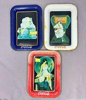 All three Coca-Cola tip trays front view