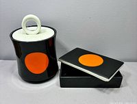 Cylindrical canister and rectangular box with lids displayed