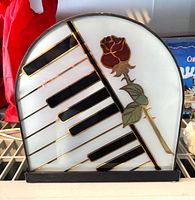 Front view of stained glass lamp showing keyboard and rose design