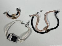 Photo shows all three jewelry pieces: two necklaces and one bracelet placed on a flat surface, displaying their layout and colors.