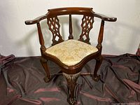 Front view of the Chippendale style mahogany corner chair, showing the upholstered seat and carved legs.