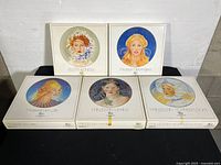 Five Hutschenreuther collector plates in original packaging arranged in two rows showing box tops with princess portraits and names.