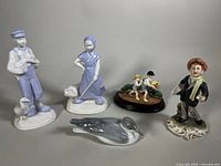 Full view of five figurines including the Trisha Romance limited edition and newsboy figure.