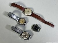Overview of four watches on white background showing relative sizes and strap/band types