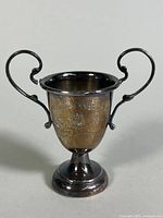 Front view of the sterling silver trophy cup showing engraved inscription and emblem.