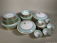Full assortment of plates, bowls, teacups, saucers and lidded serving bowls arranged on table