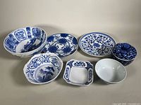 View of all seven items: two large plates, four bowls of varying sizes, and one lidded jar arranged in a single row.
