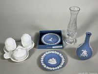 Photo showing white porcelain sugar bowl and salt and pepper shakers with two Wedgwood blue jasperware trinket dishes and two blue jasperware bud vases alongside Wedgwood lead crystal bud vase.