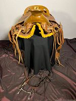 Front view showing saddle seat, leather straps, and yellow fleece padding underneath the saddle edges.