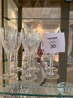 All six crystal wine glasses displayed on cabinet shelf