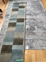 Photo showing both the runner rug and area rug side by side on wooden flooring, depicting the patterns and relative sizes.