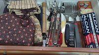 Overview of various barbecue grilling tools including tongs, forks, spatulas, metal trays, fabric oven mitts/bags, and grilling accessories.