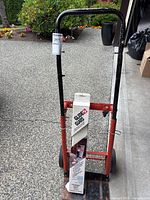 Front view of the metal hand dolly showing Glide Guard floor protectors and red frame.