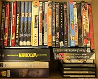 Box 1 showing rows of DVD spines including We Live in Public, several The Simpsons seasons, Watchmen, Toy Story and others