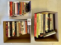 Overview of three groupings of books in two boxes and one tray