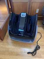 Massager removed from box showing housing, control panel, foot sleeves and power cord