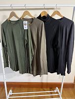 Four Ibex long-sleeve tops hanging on rack