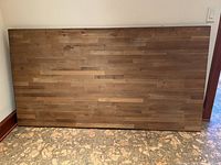Full view of rectangular butcher block tabletop leaning against wall