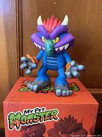 Front view of vinyl figure standing on box