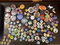 Wide view of assorted pin-back buttons grouped by size and theme