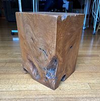 Angled view of hardwood cube showing front and side with knots and voids