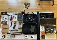Overview of table with boxed mounts, tripods, Insta360 kits, ring light, and accessories