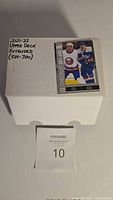 Photo showing the white storage box labeled '2021-22 Upper Deck Extended (501-700)' with an example hockey card on top.