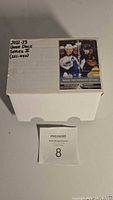 White storage box with label indicating 2022-23 Upper Deck Series 2 hockey cards set (251-450) with images of two player cards on the label