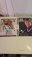 Two hockey hardcover books placed side by side: 'The Spirit of the Game' with hockey players on the cover and '99 Wayne Gretzky My Life in Pictures' featuring Wayne Gretzky in jersey.