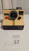 Front view of the vintage Polaroid OneStep Sears instant camera showing lens, shutter button, and front details.