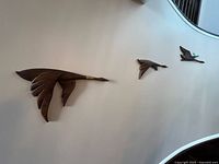 Three wooden Canada geese mounted on the wall showing overall arrangement and size difference.