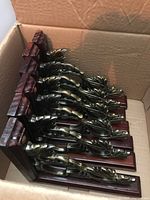 Photo of seven wood and metal decorative shelf brackets inside a cardboard box, showing the stacked condition and design elements.