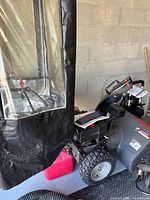 Side view showing snow blower and red resin jerry can