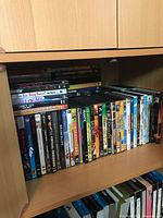 Photo showing DVDs on a shelf, with visible titles Are You Being Served? The Movie, All of Me, The Longest Yard, and others.