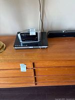 Magnasonic DVD Player and Emerson Research clock radio with visible product details and AM/FM tuning bands.