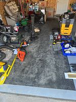Full view of the mat in a garage surrounded by various tools and equipment, showing its size and placement.