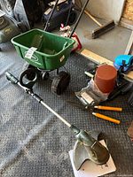 Photo of entire lot showing Scotts 1000 spreader, Yardworks electric trimmer, garden clippers, bulb planter, knee pads, and hand trowel.