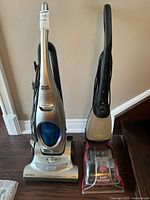 Photo showing both Shark Roadster Euro Pro vacuum and Dirt Devil Easy Steamer side by side on floor.