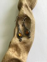 Front view of both earrings on driftwood showing overall design