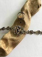 Bracelet with onyx centerpiece and ring on driftwood