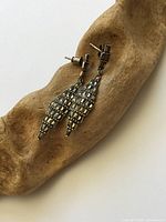 Both earrings on driftwood showing overall design