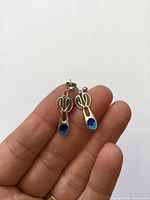 Pair of sterling silver blue-green enamel drop earrings shown on hand for scale