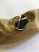 Front view of silver ring with wrapped setting around dark stone