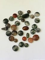 Overview of assorted agate cabochons on white background